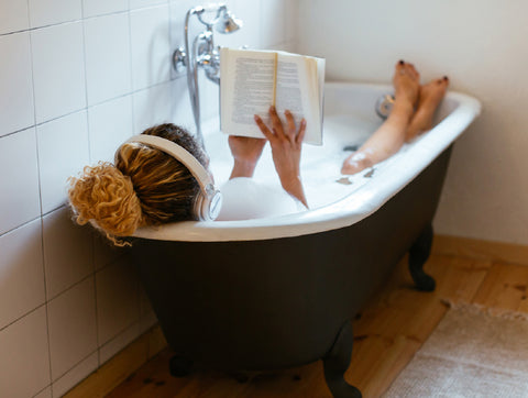 girl reading in bubble bath tub