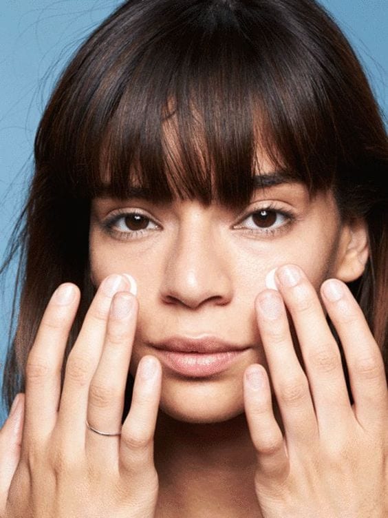 girl putting moisturizer on face