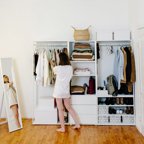 person going through closet of clothes