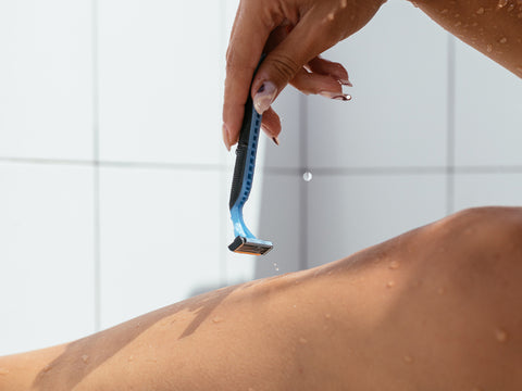 hand shaving leg with razor