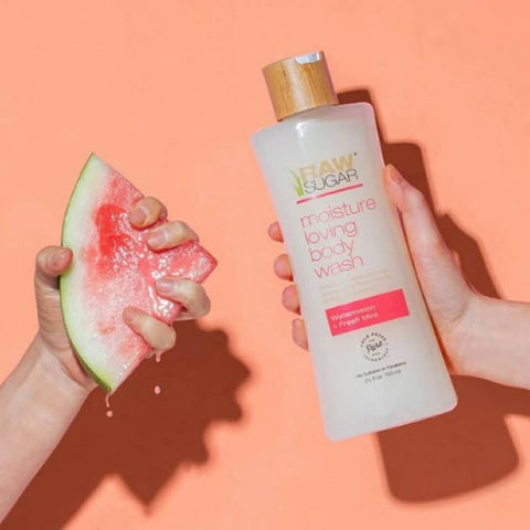 watermelon being squeezed in left hand Raw Sugar Moisture Loving Watermelon + Fresh Mint body wash in right hand