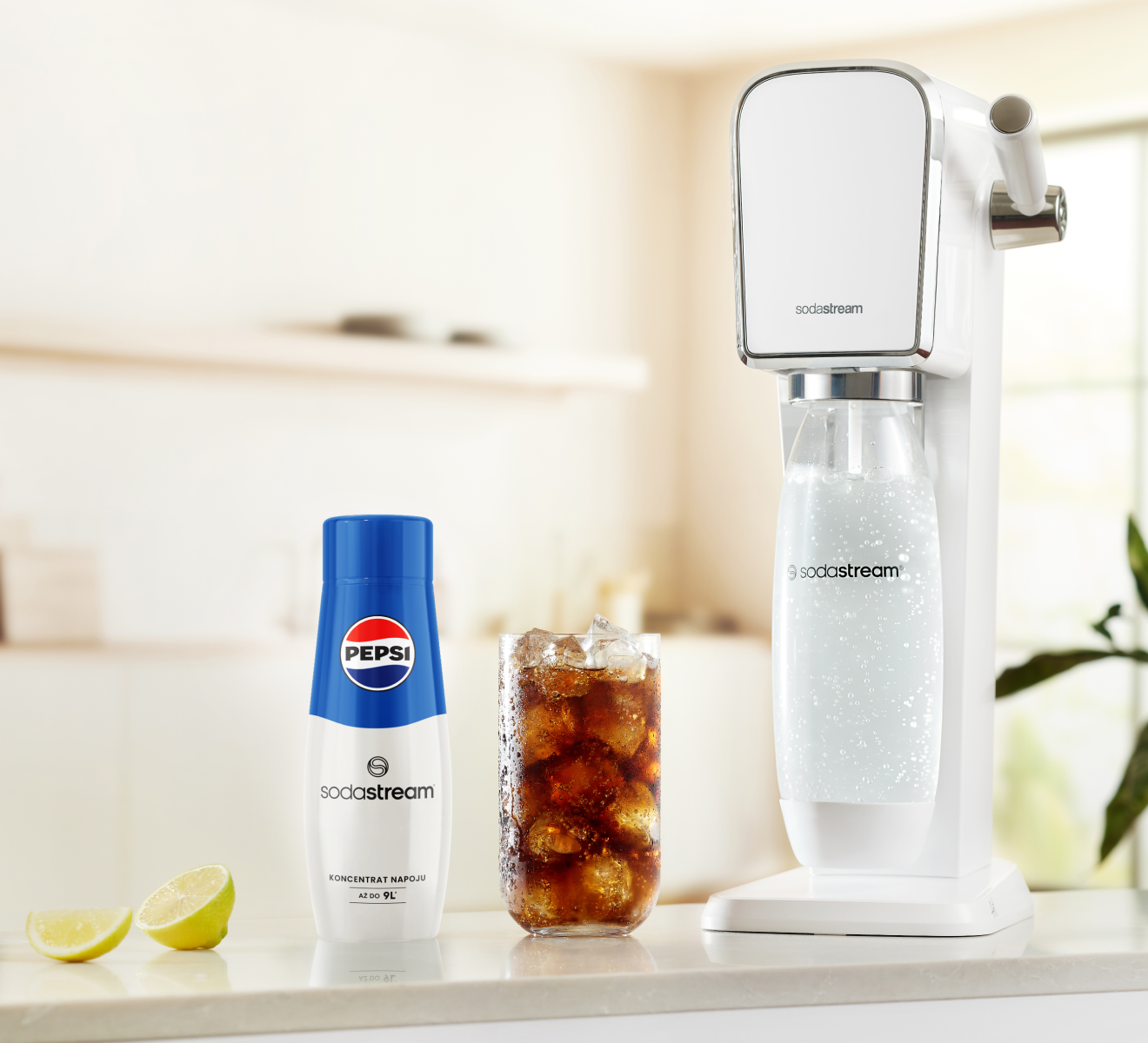 Saturator SodaStream podczas gazowania wody. Obok stoi sok Pepsi.
