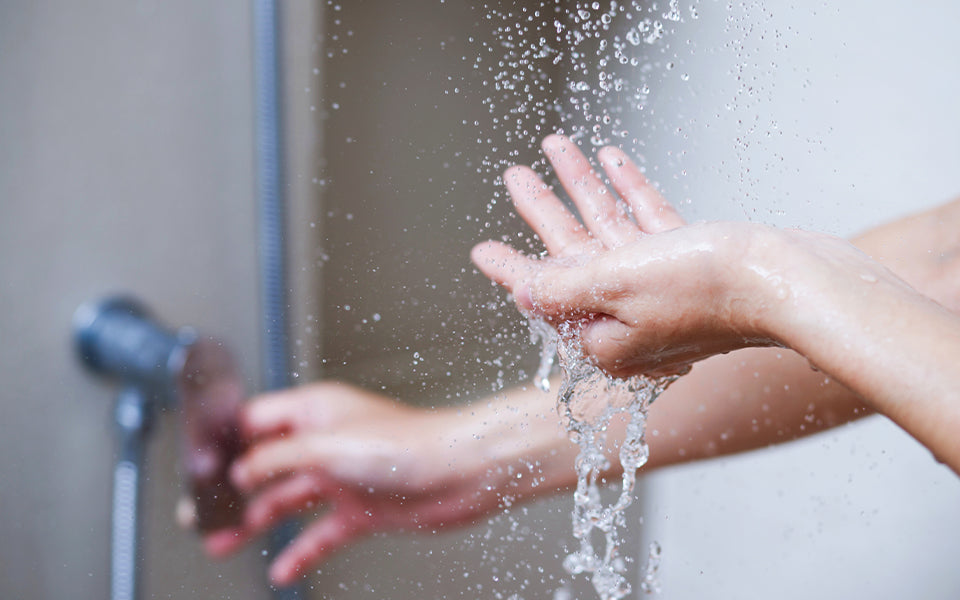 Sprawdzanie temperatury wody pod prysznicem - zdjęcie.