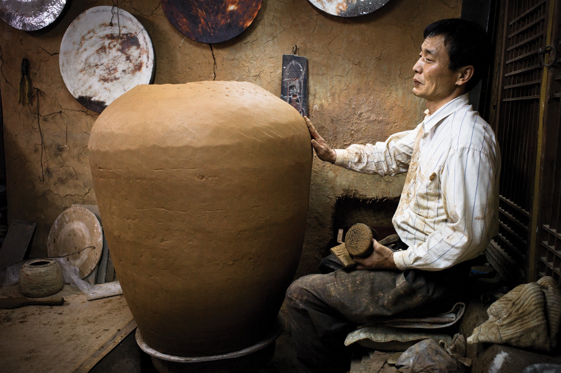 Kang-hyo Lee making a giant onggi jar at his studio in South Korea photographed by Jay Goldmark