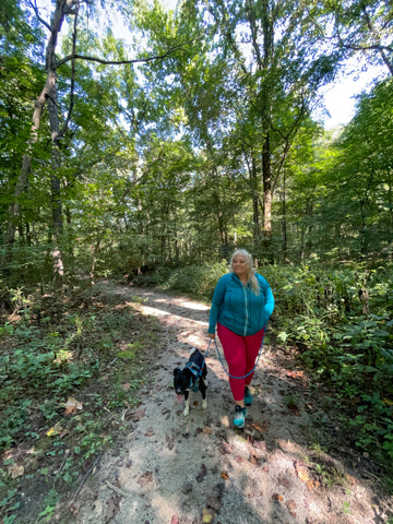 Jenny, founder of Unlikely Hikers, and Big Judy the Border Collie Mix are taking a hike in the woods. 