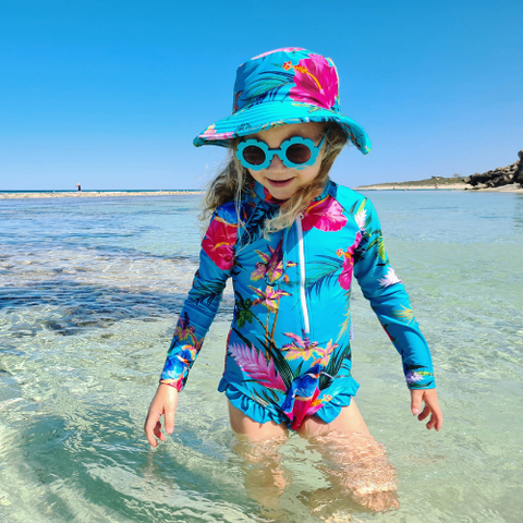 girl wears sun protective swimsuit and beach bucket hat from Tribe Tropical Australia