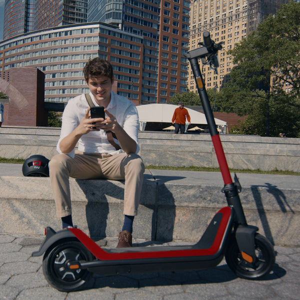 Man using NIU app to configure KQi3 Sport electric kick scooter