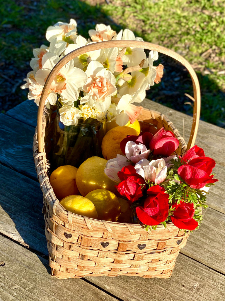 Fancy daffodils and anemones in a basket with lemons