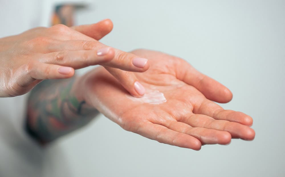 Person rubbing herbal remedy on hands