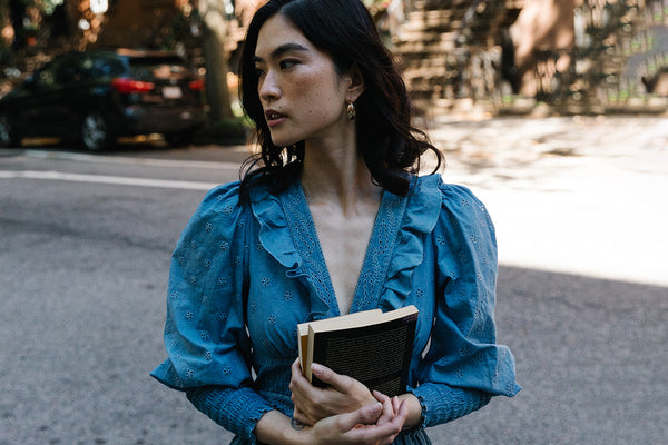 woman with black hair wearing blue organic cotton dress