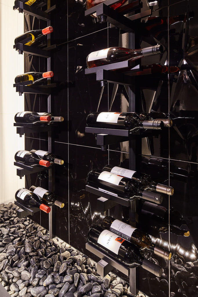 The wine cellar’s lighting runs down to the black tiled floor with pebbles around it