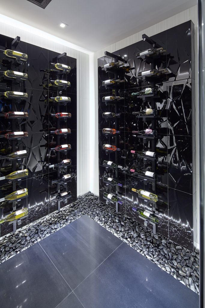 The lighting system emphasizes the wine cellar’s details