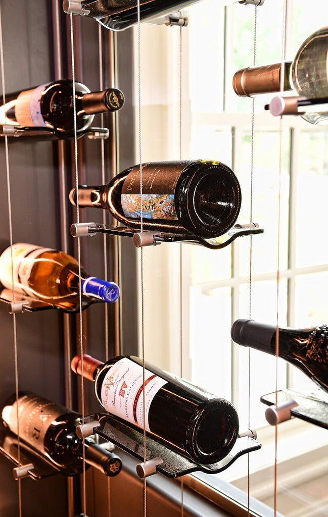 Closeup of wine bottles on glass floating shelves