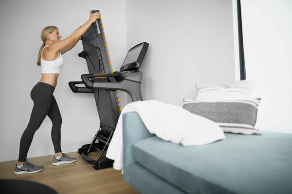 blond woman folding a treadmill to 90 degrees