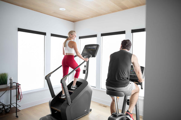 woman on stair stepper, man on bike