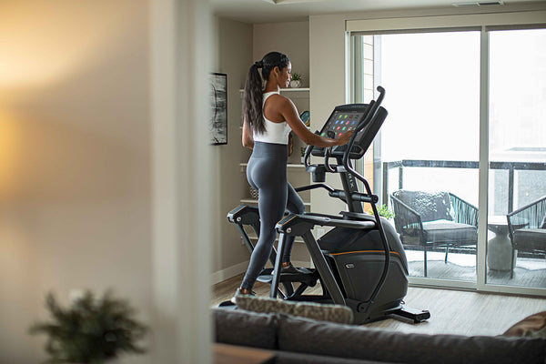woman at home on an elliptical