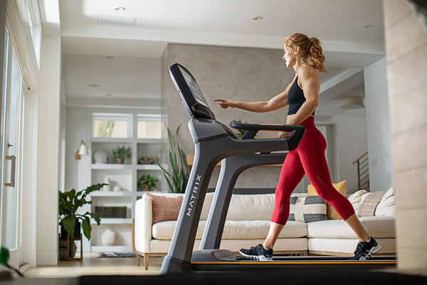 red haired woman walking on a treadmill