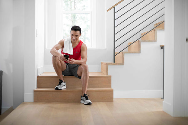 man sitting on the staircase looking at his phone