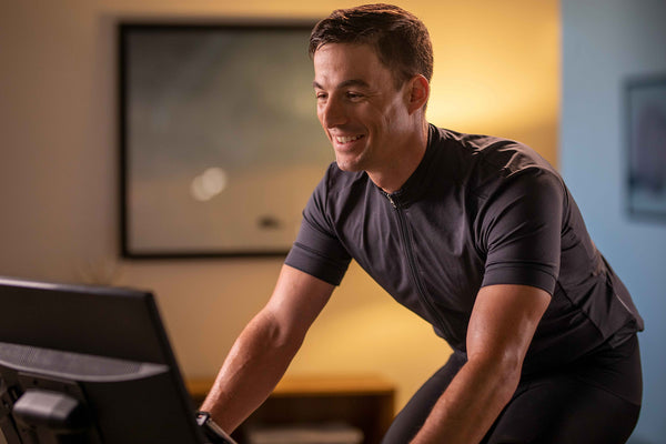 man riding indoor cycle and smiling