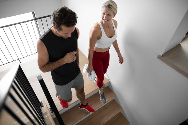 man and woman walking down a flight of stairs