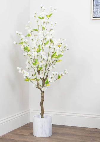 An artificial cherry tree in a white pot in the hallway's corner.