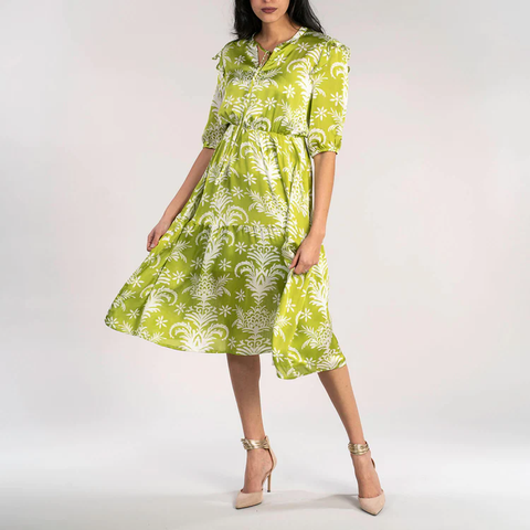 Lady in lime and white coloured flowy, floral dress.