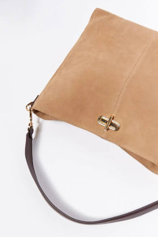 A light brown leather bag with a dark brown strap, gold details and a gold clasp.