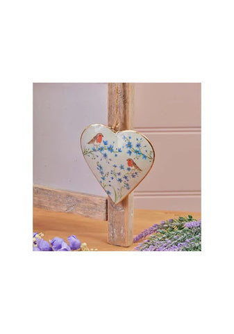 A metal heart wall hanging with robins and forget-me-not decorations.