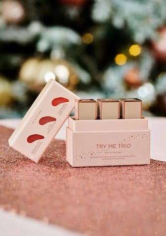 A pink box with three lipsticks inside, with the words “Try Me Trio” written on the front in red.