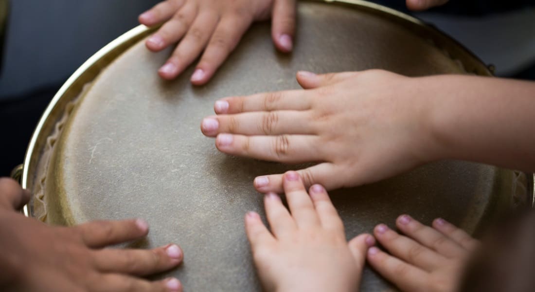 Des mains d'enfants sur la peau d'un Djembé