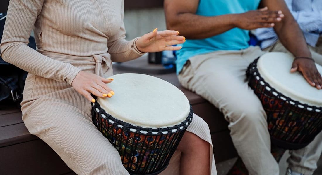 Deux personnes qui jouent avec un Tambour africain