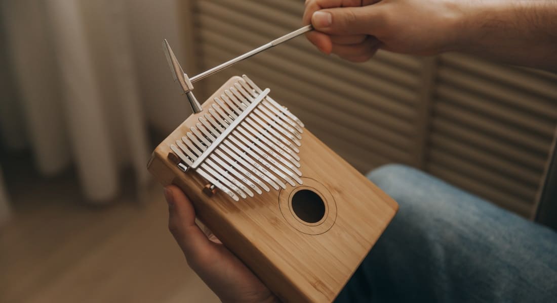 Un homme qui accorde son Kalimba avec un marteau