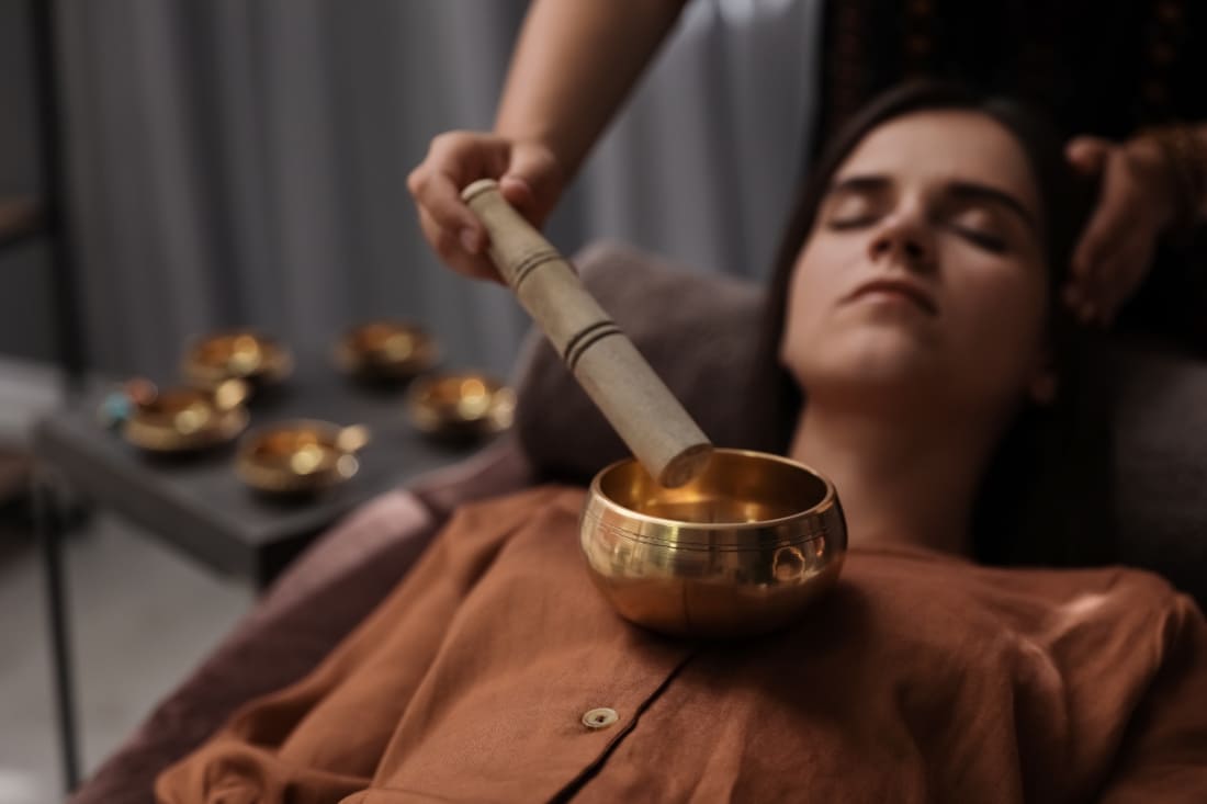 Un massage sonore avec Bol Tibétain réalisé sur une femme