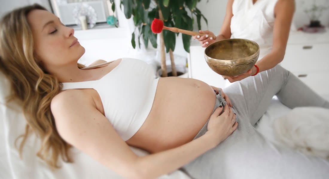 Une Femme en Gestation allongée pendant un massage sonore