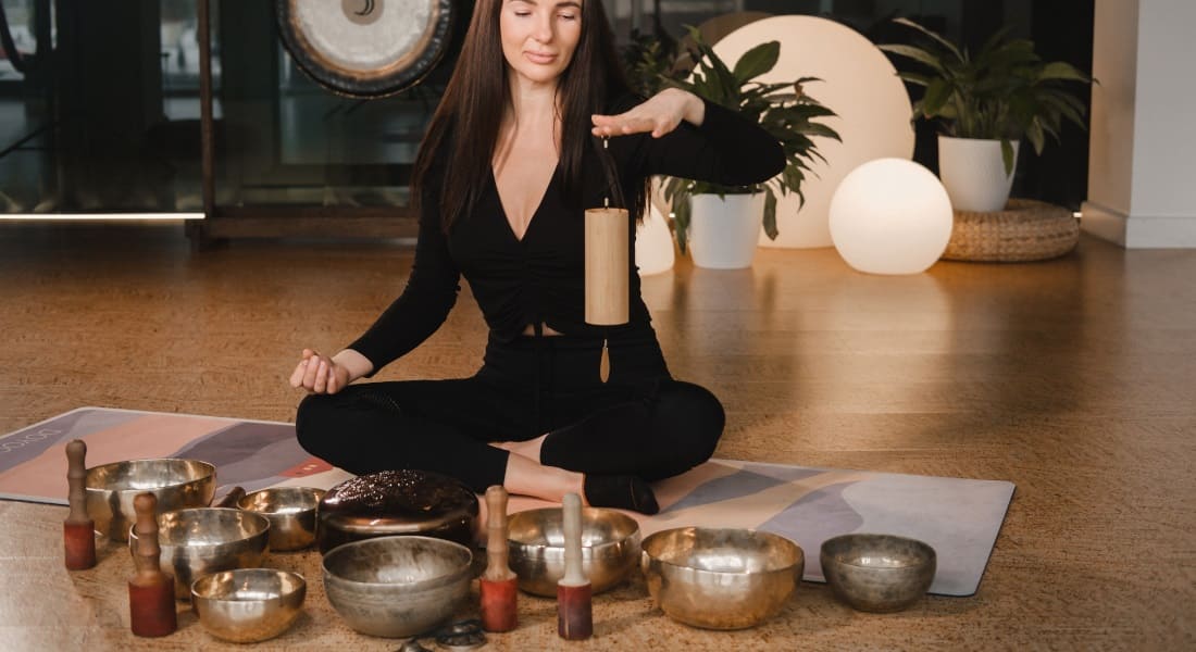 Une femme avec un carillon entourée de Bols Chantants