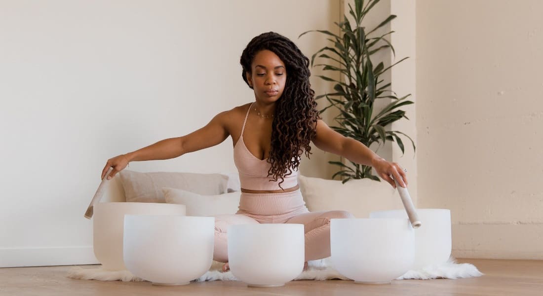 Une femme noire qui utilise des Bols Chantants en cristal