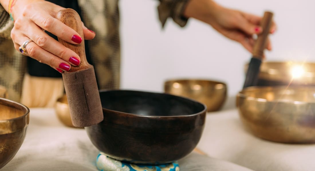 Une femme pratiquant la Sonothérapie avec des Bols Tibétains