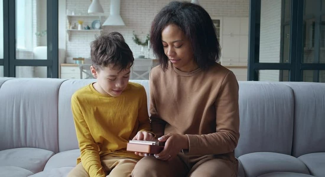 Une femme qui montre à un enfant comment jouer du Kalimba