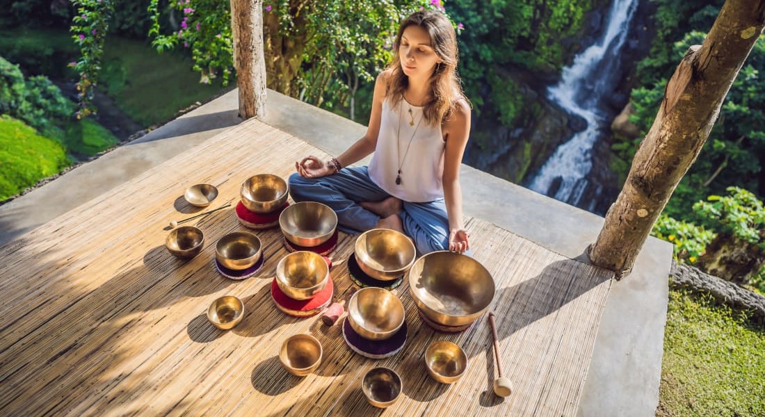 Une femme vue de contreplongée entourée de Bols Tibétains