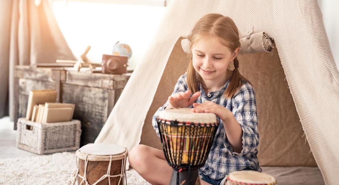 Une fille qui joue avec un Djembé dans sa chambre