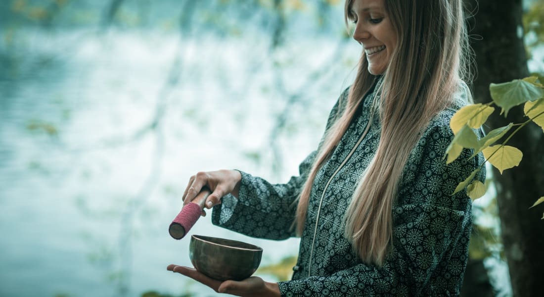 Une jeune femme souriante qui utilise un Bol Chantant