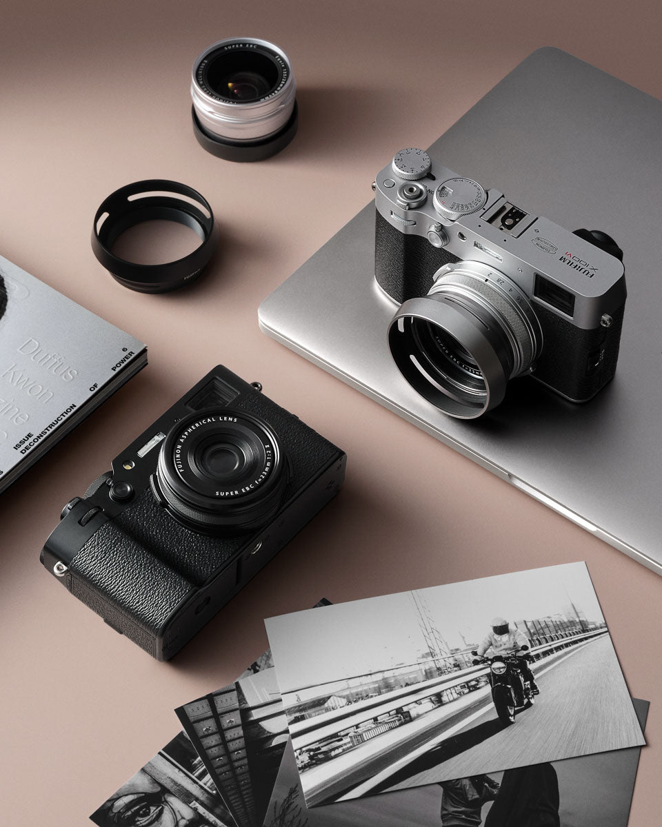 Photo of the cameras both in silver & black on an organised desk