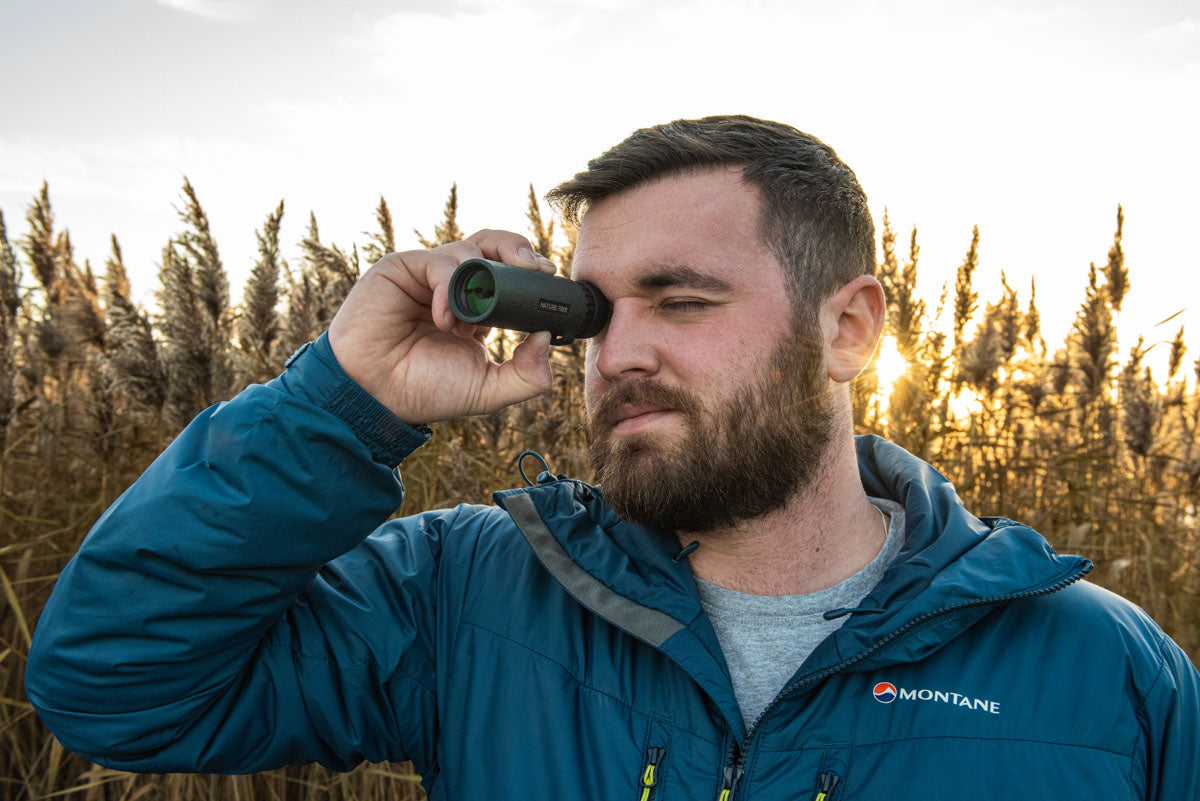 Man in the field using the nature-trek monocular form Hawke