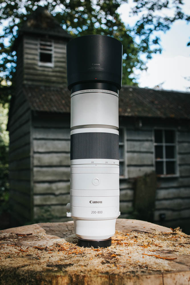 Portrait photo of the lens next to an abandoned building