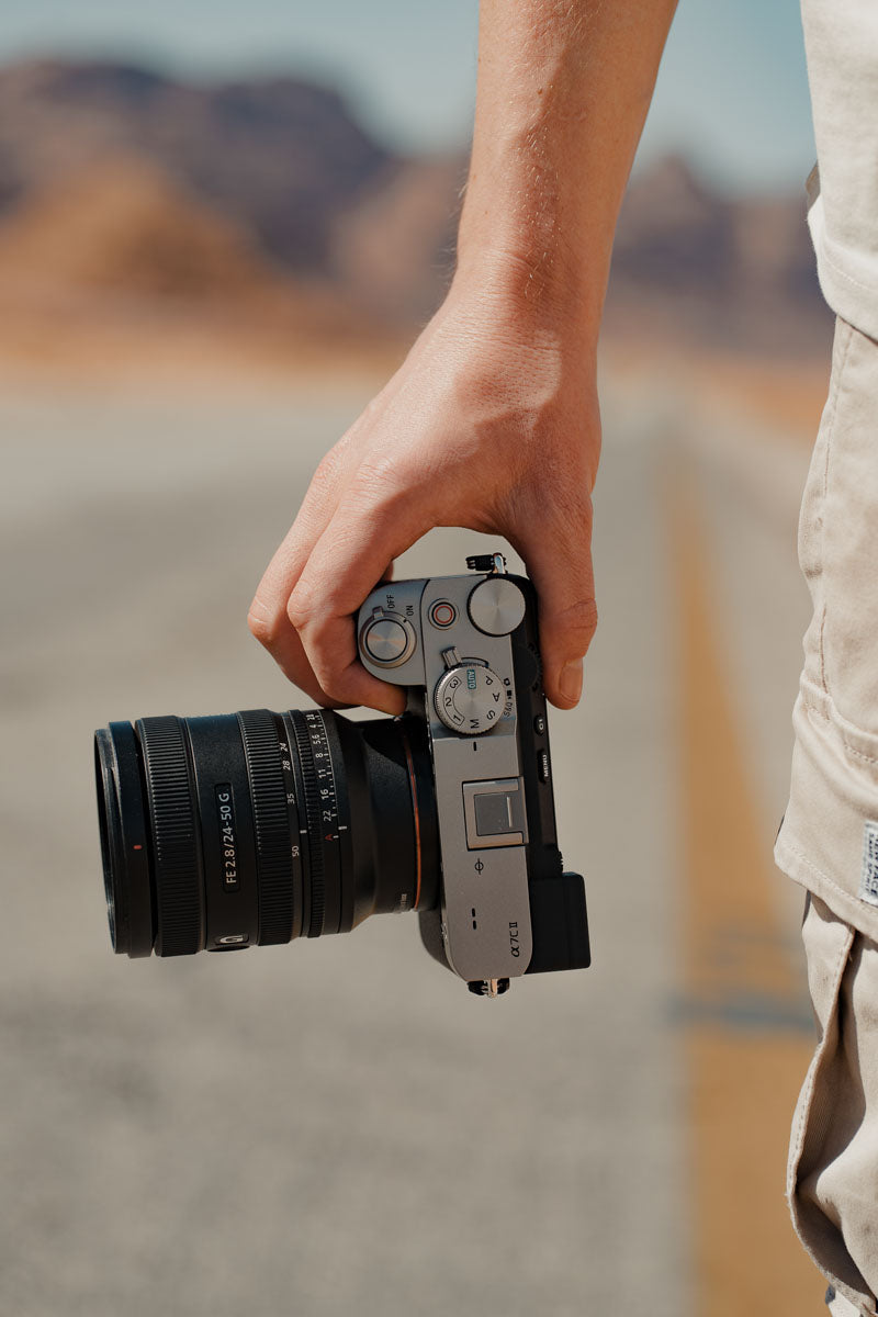 Photo of a photographer holding the lens attached to a camera body