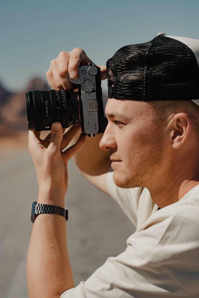 Sony FE 24-50MM F2.8G camera lens in use with a photographer in the desert