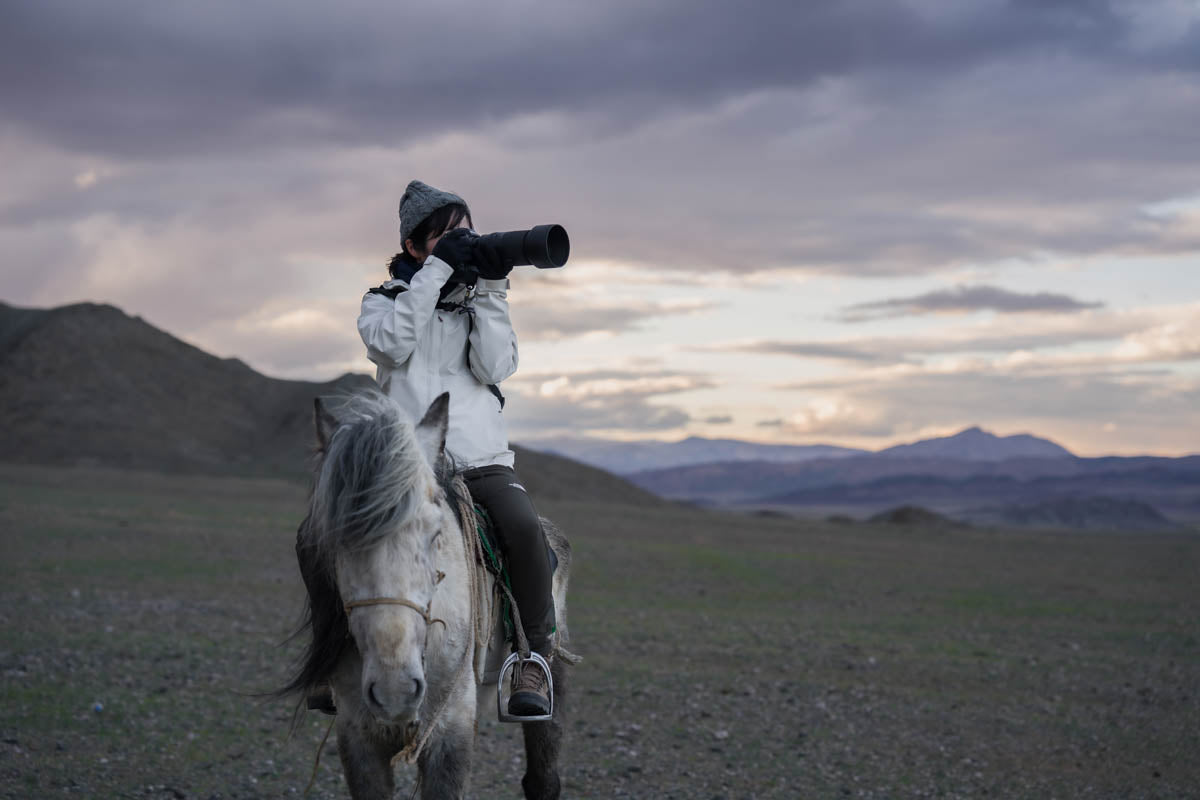 Photo of a lady on horseback in Asia taking photos