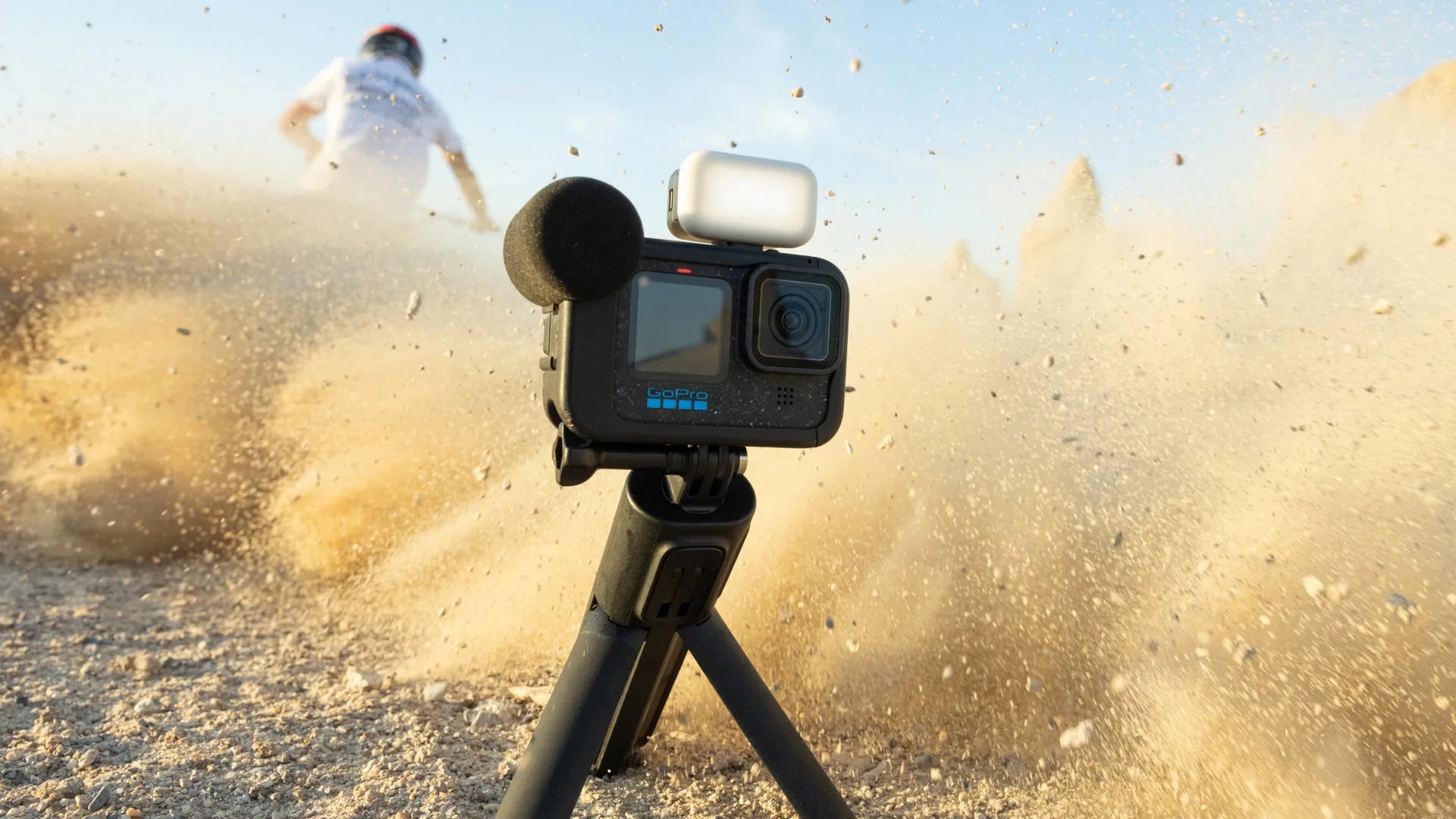 GoPro mounted to a tripod with a dirt bike in the background