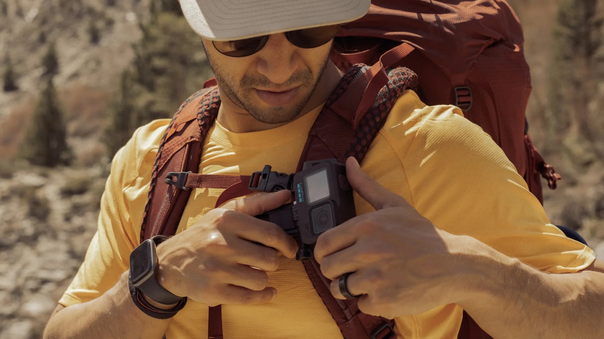 Photo of the gopro swivel clip attached to a bag worn by a hiker in the mountains