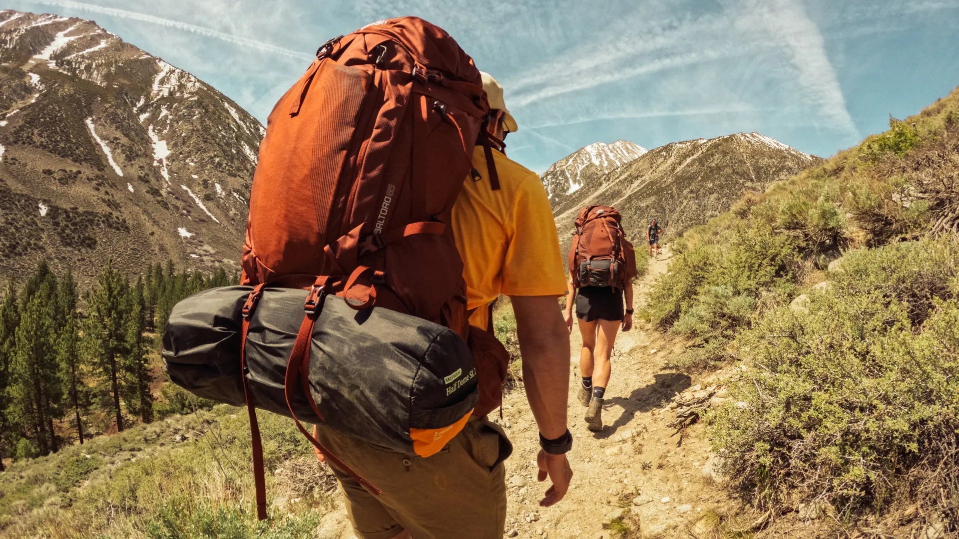 GoPro camera clip attached to a hikers backpack in the sunny mountains